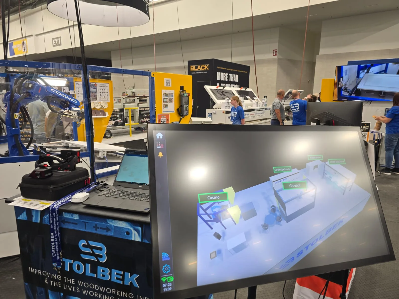 OnoTwin on the Stolbek stand — a digital twin of a woodworking line on screen, robot cell behind